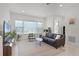 Bright living room featuring a comfortable sofa, stylish decor, and large windows offering neighborhood views at 10108 Sunnifa Aly, Orlando, FL 32832