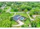 An aerial view shows a home with a screened pool, driveway, mature trees, and manicured lawn at 1071 Deer Run Dr, Winter Springs, FL 32708