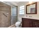 This remodeled bathroom includes a tiled shower, dark wood vanity, and stylish mirror at 1071 Deer Run Dr, Winter Springs, FL 32708