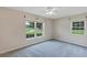 Bright bedroom featuring two windows providing natural light, neutral walls, and soft gray carpeting for a comfortable space at 1071 Deer Run Dr, Winter Springs, FL 32708
