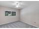 Neutral bedroom featuring a ceiling fan, plush carpet, and a window offering natural light and outdoor views at 1071 Deer Run Dr, Winter Springs, FL 32708