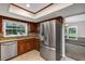 Updated kitchen with stainless steel refrigerator, granite counters and wood cabinetry at 1071 Deer Run Dr, Winter Springs, FL 32708