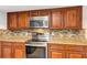 Modern kitchen with stainless steel appliances, granite countertops, and mosaic backsplash at 1071 Deer Run Dr, Winter Springs, FL 32708