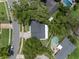 Aerial view of a home with a dark roof and adjacent pools in a lush, green neighborhood at 1105 Appleton Ave, Orlando, FL 32806