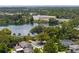 An aerial shot reveals homes nestled among mature trees near a serene lake with a modern building visible at 1105 Appleton Ave, Orlando, FL 32806