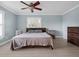 Bedroom featuring light blue walls, a ceiling fan, and a window with shutters at 1105 Appleton Ave, Orlando, FL 32806