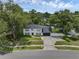 Two-story home with a dark roof, dark shutters, green lawn, and large trees at 1105 Appleton Ave, Orlando, FL 32806