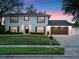 Two-story home with dark shutters and a black roof, complemented by a meticulously maintained lawn at 1105 Appleton Ave, Orlando, FL 32806