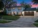 Two-story home featuring a dark roof, black shutters, and a well-manicured front lawn at 1105 Appleton Ave, Orlando, FL 32806
