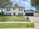 Two-story home featuring manicured lawn, driveway, and two-car garage at 1105 Appleton Ave, Orlando, FL 32806