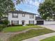 Two-story home featuring manicured lawn, driveway, and two-car garage at 1105 Appleton Ave, Orlando, FL 32806