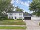 Charming two-story home with a well-manicured lawn, dark shutters, and a black front door at 1105 Appleton Ave, Orlando, FL 32806