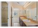 Bathroom with double sinks, large mirror, and an open doorway to the bedroom at 1210 San Jacinto Cir, Sanford, FL 32771