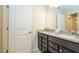 Bright bathroom features a double vanity with granite countertop and dark wood cabinets at 1292 Blue Island Dr, Clermont, FL 34714