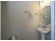 Simple powder room with pedestal sink, round mirror, and neutral wall paint at 1292 Blue Island Dr, Clermont, FL 34714