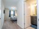 View from hallway into bedroom and connected bathroom with a double granite vanity at 1292 Blue Island Dr, Clermont, FL 34714