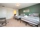Bright bedroom featuring twin beds, a green accent wall, and a desk and chair at 1292 Blue Island Dr, Clermont, FL 34714