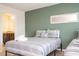 Comfortable bedroom featuring twin beds, a green accent wall, and a decorative mirror at 1292 Blue Island Dr, Clermont, FL 34714