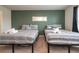 Bedroom features twin beds, a green accent wall, and a decorative mirror at 1292 Blue Island Dr, Clermont, FL 34714