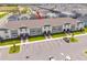 Aerial view of townhomes with ample parking, landscaping, and grey-and-white exterior at 1292 Blue Island Dr, Clermont, FL 34714