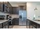 Modern kitchen featuring stainless steel appliances, granite countertops and dark wood cabinetry at 1292 Blue Island Dr, Clermont, FL 34714