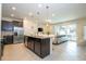 Modern kitchen with dark cabinets, stainless steel appliances, and granite countertops overlooking living area at 1292 Blue Island Dr, Clermont, FL 34714