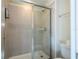 Clean shower with glass door, white tile, shower head, and a built-in shower caddy at 1292 Blue Island Dr, Clermont, FL 34714