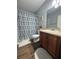 Bathroom with wood floors, vanity with beige countertop, and blue patterned shower curtain at 13207 Villa Vista Dr # 205, Orlando, FL 32824