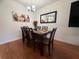 Dining room with a dark wood table, seating for six, and a decorative mirror at 13207 Villa Vista Dr # 205, Orlando, FL 32824