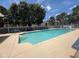 Community pool surrounded by lounge seating, lush trees and landscaping at 13207 Villa Vista Dr # 205, Orlando, FL 32824
