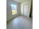 This bedroom features tiled floors, a window, and a closet with sliding doors at 1557 Venice Ln, Davenport, FL 33896