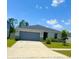 A charming single-story home featuring a well-maintained lawn and a two-car garage on a sunny day at 1557 Venice Ln, Davenport, FL 33896