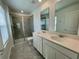 Bathroom features double sinks, a glass-enclosed shower, and large mirrors above the vanities at 15579 Water Spring Blvd, Winter Garden, FL 34787