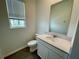 Bathroom featuring modern mirror, quartz vanity, tile floors, and a bright, airy window at 15579 Water Spring Blvd, Winter Garden, FL 34787