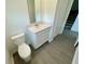 Bathroom with a white quartz vanity, chrome hardware, tile floors, toilet, and access to the stairwell at 15579 Water Spring Blvd, Winter Garden, FL 34787