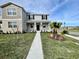 Beautiful two-story home with a covered front porch, a well-maintained lawn, and lush landscaping at 15579 Water Spring Blvd, Winter Garden, FL 34787