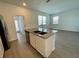 Open-concept kitchen with gray counters, stainless steel appliances, and gray plank floors at 15579 Water Spring Blvd, Winter Garden, FL 34787