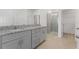 Bright bathroom featuring a double vanity with granite countertop and a glass-enclosed shower at 1580 Gardiner St, Haines City, FL 33844