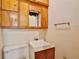 Simple bathroom featuring a tiled wall, toilet, sink, and storage cabinet at 1607 Lindale Ave, Eustis, FL 32726