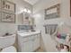 A well-lit bathroom with a modern vanity, framed mirror, and charming artistic decor, offering a clean and inviting space at 210 Magnolia Rd # 214, Maitland, FL 32751
