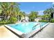 Community pool with clear blue water, inviting lounge chairs, and tropical palm trees, creating a resort-like atmosphere at 210 Magnolia Rd # 214, Maitland, FL 32751
