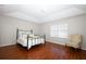 Bedroom featuring an iron bed frame, wood floors, and a comfortable chair at 2205 Wyndam Way, Kissimmee, FL 34743