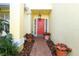 Inviting front entrance with a red door, decorative plants, and a brick pathway at 2205 Wyndam Way, Kissimmee, FL 34743