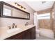 Bathroom with a double vanity, large mirror, and a shower-tub combination at 2223 Fairmont Cir, Orlando, FL 32837