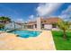 Backyard pool, patio and lawn of home with blue lounge chairs and covered patio at 2223 Fairmont Cir, Orlando, FL 32837