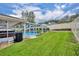 Serene backyard view with a screened-in pool area, manicured lawn, and privacy fencing at 2265 Turnberry Dr, Oviedo, FL 32765