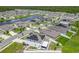 Aerial view showcases a residential neighborhood with houses, streets, a lake, and solar panels at 242 White Heron Way, St Cloud, FL 34772