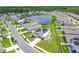 High aerial of a modern home in a residential neighborhood with solar panels, a pond, and green spaces at 242 White Heron Way, St Cloud, FL 34772