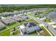 An aerial view of a neighborhood featuring modern homes, solar panels, and a lush, green environment at 242 White Heron Way, St Cloud, FL 34772