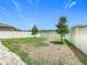 A large, grassy backyard with white picket and vinyl fencing under a blue sky at 242 White Heron Way, St Cloud, FL 34772